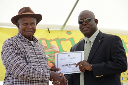 Minister of Agriculture on Nevis Hon. Robelto Hector (r) presents over a certificate of Appreciation to Brown Hill Fisherman/Farmer Mr. Luther Williams at the opening ceremony of the 18th annual Agriculture Open day hosted by the Department of Agriculture under his patronage